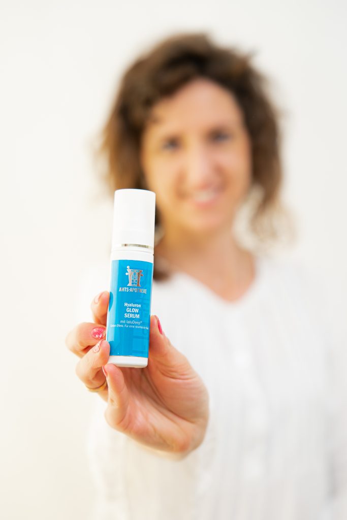 Frau präsentiert eine Creme der Amts-Apotheke