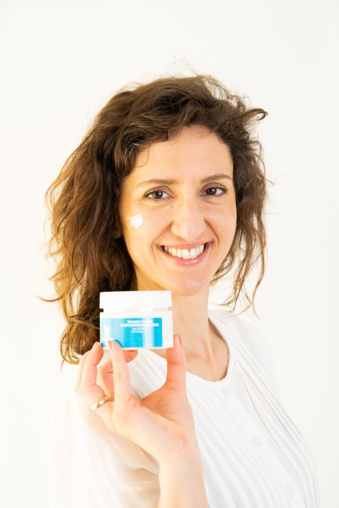 Frau präsentiert Gesichtscreme der Amts-Apotheke